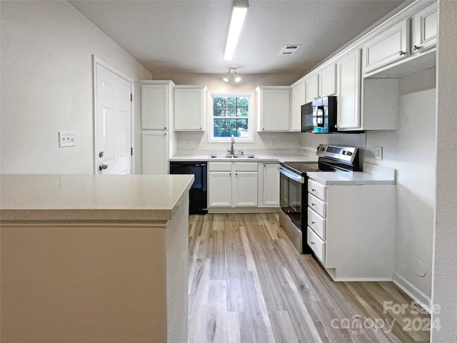 kitchen with black appliances, light hardwood / wood-style floors, white cabinetry, and sink