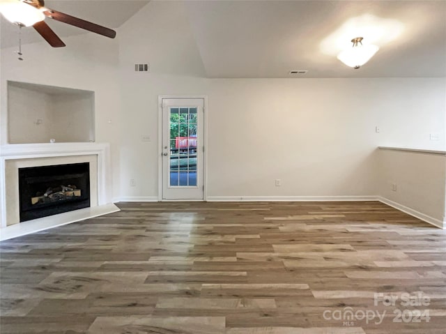 unfurnished living room featuring ceiling fan, hardwood / wood-style floors, and vaulted ceiling