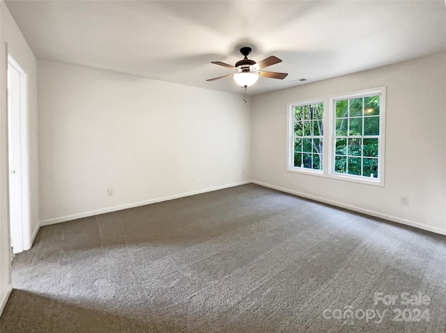 empty room with dark carpet and ceiling fan