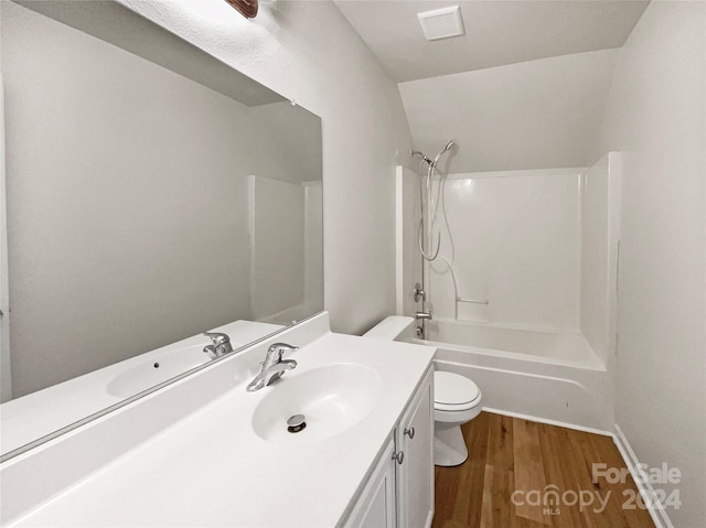 full bathroom with tub / shower combination, vanity, hardwood / wood-style floors, and toilet