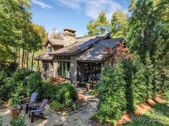 back of property with a sunroom