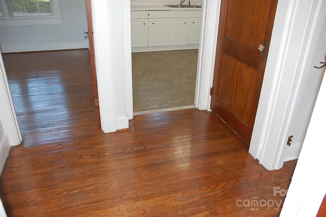 corridor featuring sink and dark wood-type flooring