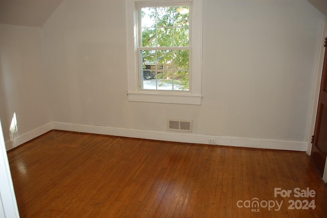 additional living space with vaulted ceiling and hardwood / wood-style floors