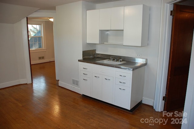 kitchen with white cabinetry, sink, and dark hardwood / wood-style flooring