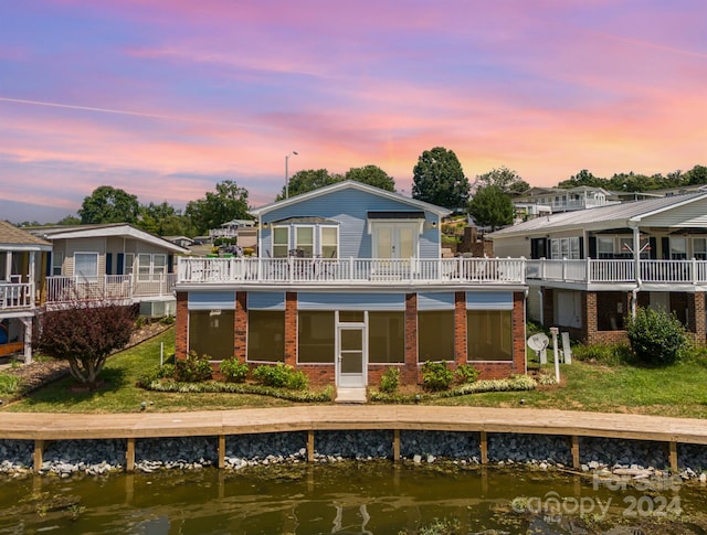 back house at dusk featuring a water view