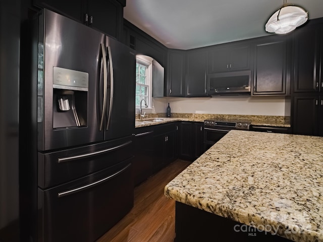 kitchen featuring dark wood-type flooring, stainless steel appliances, light stone countertops, and sink