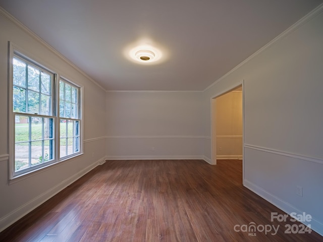 spare room featuring ornamental molding and dark wood-type flooring