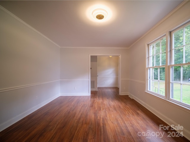 empty room featuring crown molding and dark hardwood / wood-style flooring