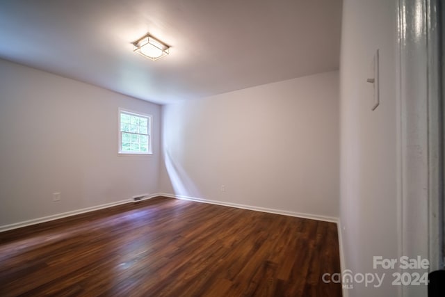 unfurnished room with dark hardwood / wood-style flooring