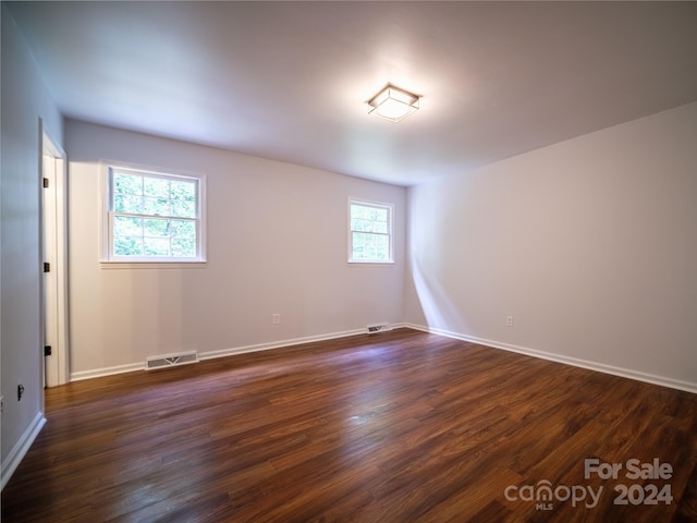 spare room with dark wood-type flooring