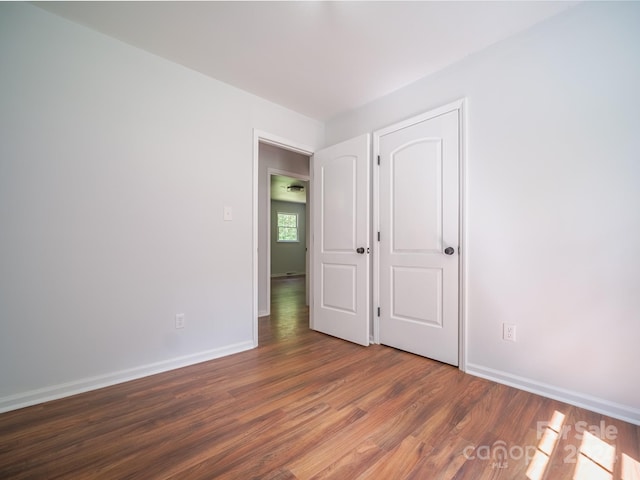 unfurnished bedroom with dark hardwood / wood-style floors