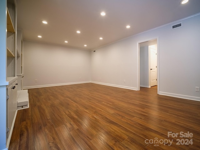 unfurnished room with crown molding and dark hardwood / wood-style floors