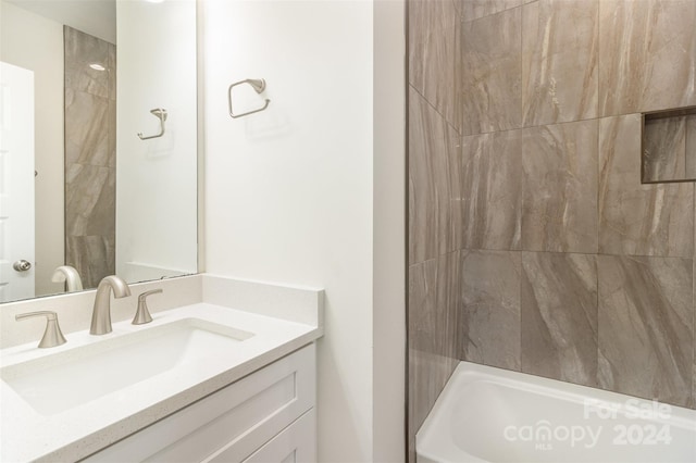 bathroom featuring vanity and tiled shower / bath combo