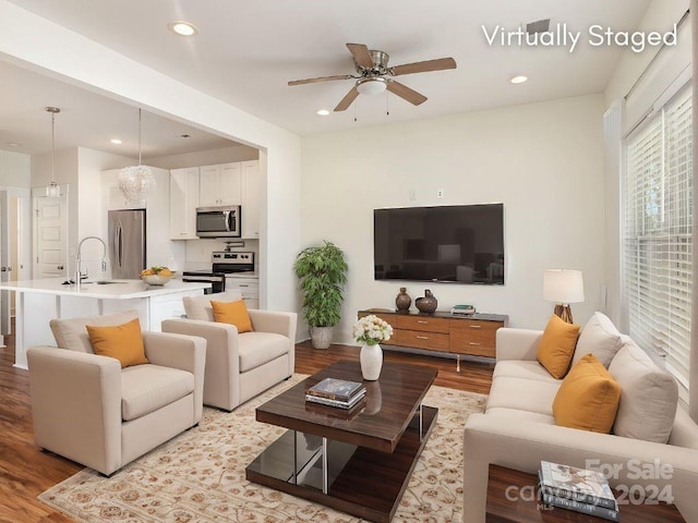 living room featuring sink, light wood-type flooring, and ceiling fan