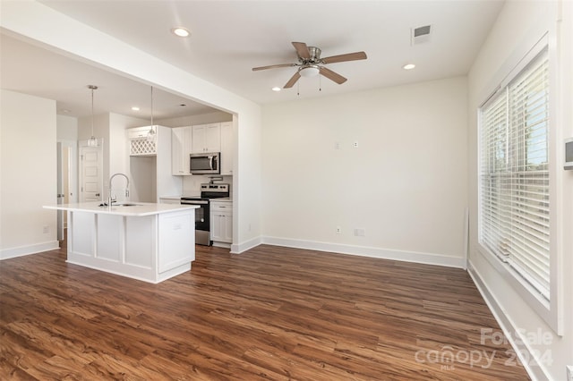 kitchen featuring appliances with stainless steel finishes, white cabinetry, decorative light fixtures, and dark wood-type flooring