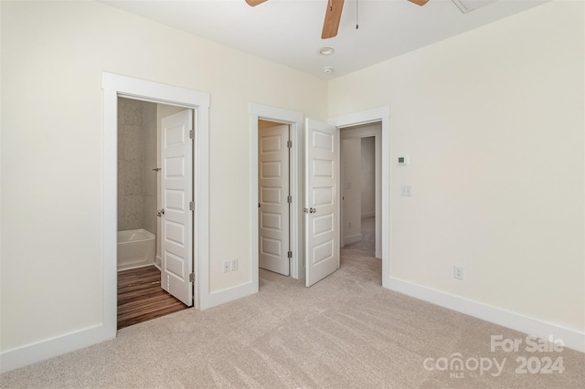 unfurnished bedroom with light carpet, ensuite bathroom, and ceiling fan