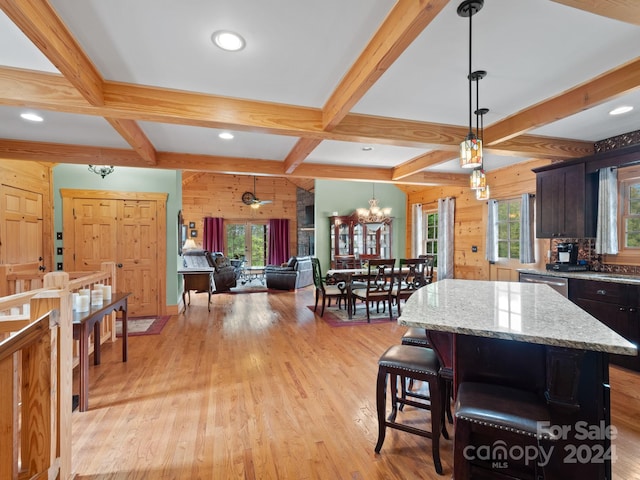 kitchen featuring light hardwood / wood-style flooring, a wealth of natural light, beam ceiling, and a kitchen island