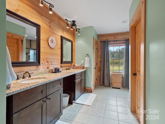 bathroom with vanity, wood walls, and tile patterned flooring