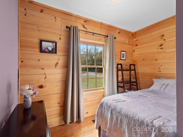 bedroom featuring wood walls and light hardwood / wood-style floors