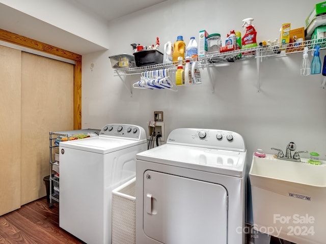 laundry area with independent washer and dryer, sink, and dark wood-type flooring