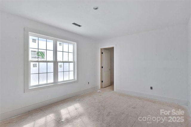 spare room featuring a healthy amount of sunlight, baseboards, and visible vents