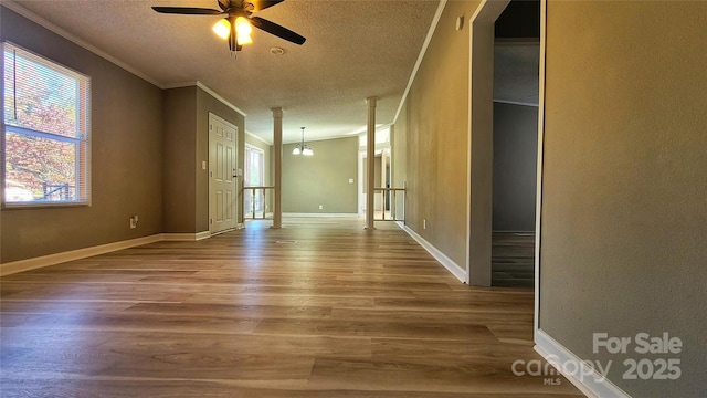 spare room with ornamental molding, wood-type flooring, and a textured ceiling