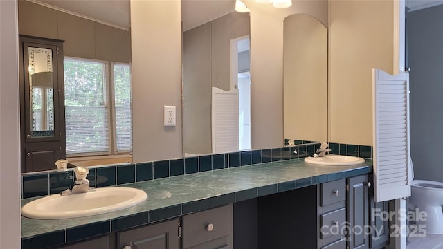 bathroom featuring vanity, toilet, and a healthy amount of sunlight