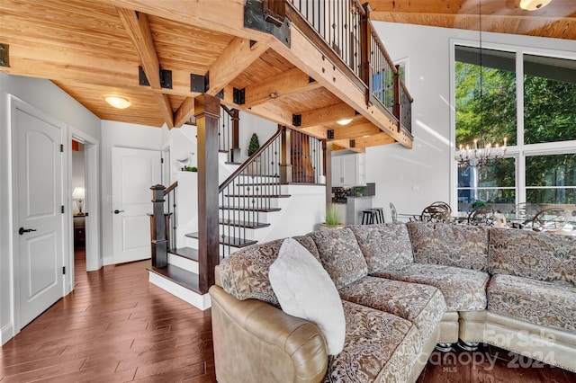 living room with beamed ceiling, an inviting chandelier, dark wood-type flooring, and wood ceiling