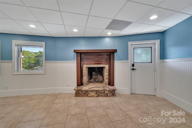 unfurnished living room featuring light tile patterned flooring and a fireplace