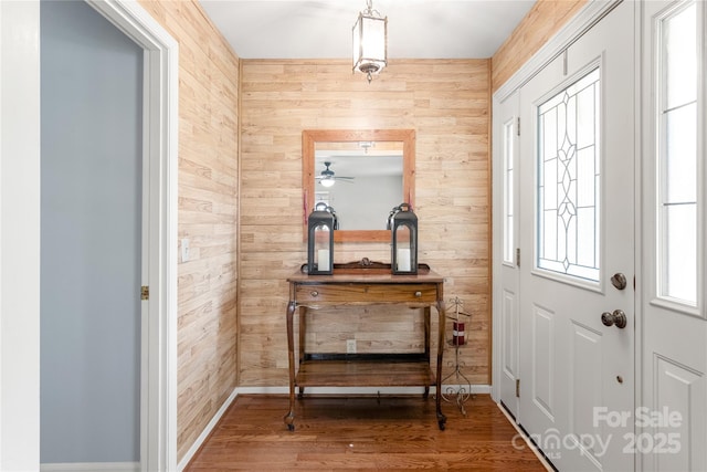 entrance foyer featuring hardwood / wood-style floors and wood walls