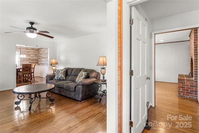 living room featuring light hardwood / wood-style flooring and ceiling fan