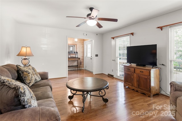 living room with ceiling fan and light hardwood / wood-style flooring