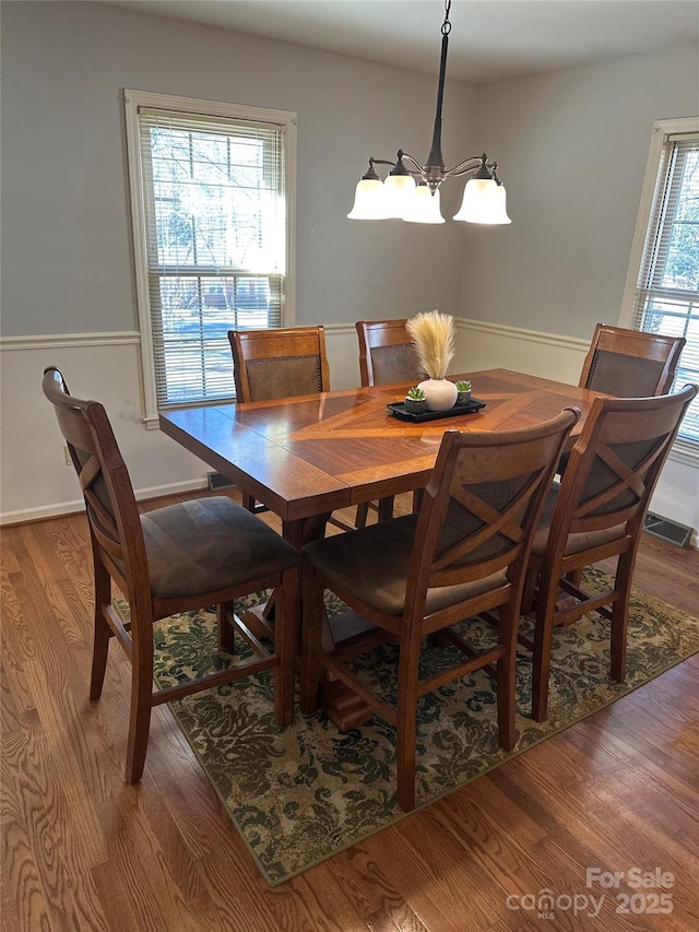 dining room featuring hardwood / wood-style floors and an inviting chandelier