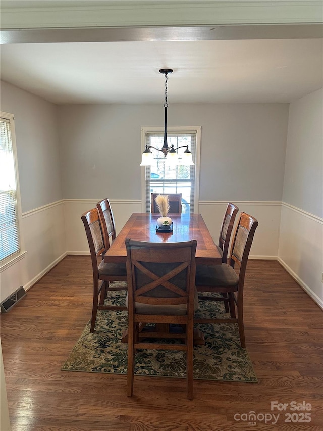 dining area featuring an inviting chandelier and dark hardwood / wood-style floors