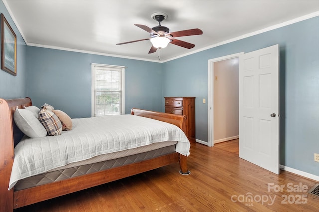 bedroom with hardwood / wood-style flooring, ceiling fan, and crown molding