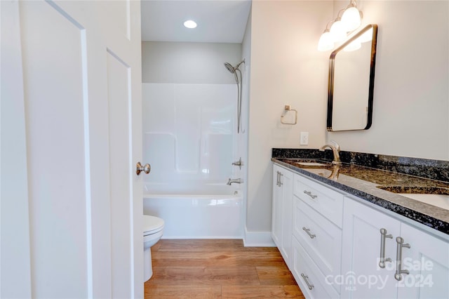 full bathroom featuring vanity, hardwood / wood-style flooring, shower / washtub combination, and toilet