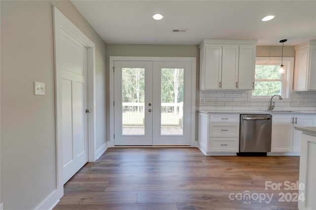 kitchen featuring white cabinets, decorative light fixtures, a healthy amount of sunlight, and stainless steel dishwasher