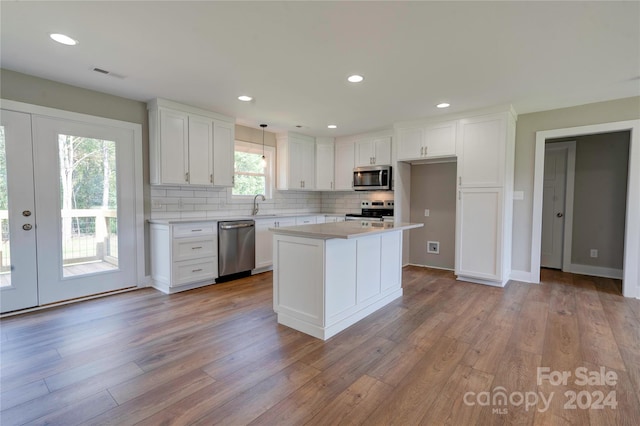 kitchen featuring french doors, white cabinets, appliances with stainless steel finishes, and light hardwood / wood-style flooring