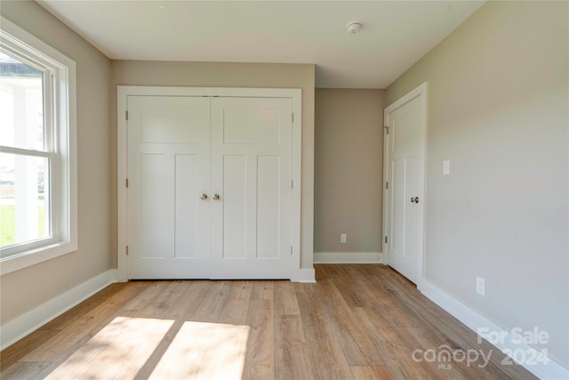 unfurnished bedroom featuring light hardwood / wood-style flooring and a closet