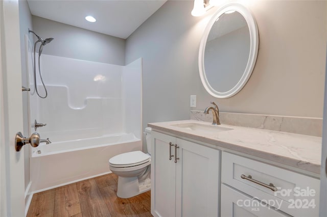 full bathroom featuring shower / tub combination, vanity, hardwood / wood-style floors, and toilet