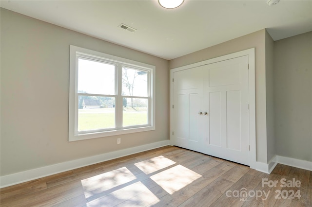 unfurnished bedroom featuring light wood-type flooring and a closet