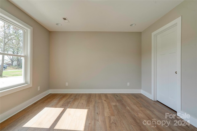 empty room with light wood-type flooring and a healthy amount of sunlight