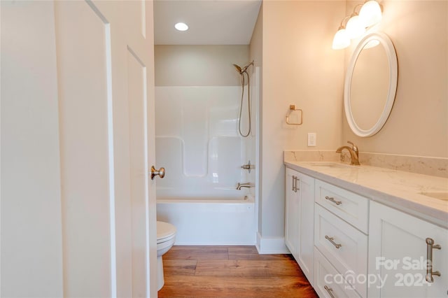 full bathroom featuring wood-type flooring, vanity, bathtub / shower combination, and toilet