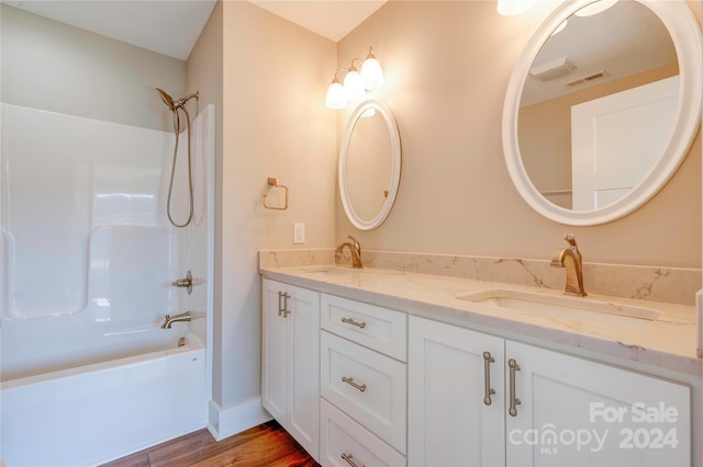 bathroom featuring shower / bathing tub combination, wood-type flooring, and vanity