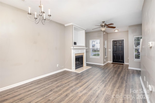 unfurnished living room featuring ceiling fan with notable chandelier, a premium fireplace, and dark hardwood / wood-style floors