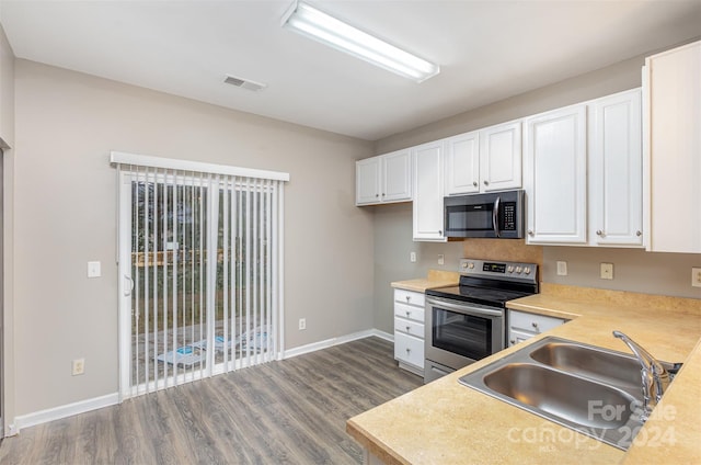 kitchen featuring white cabinetry, appliances with stainless steel finishes, dark hardwood / wood-style floors, and sink