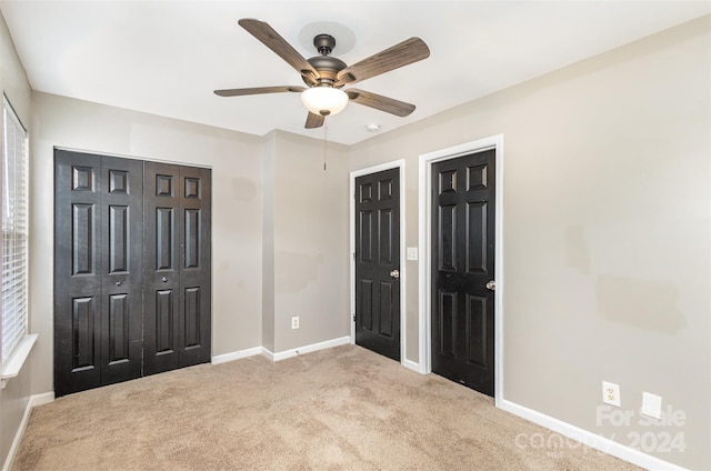 unfurnished bedroom featuring ceiling fan and light colored carpet