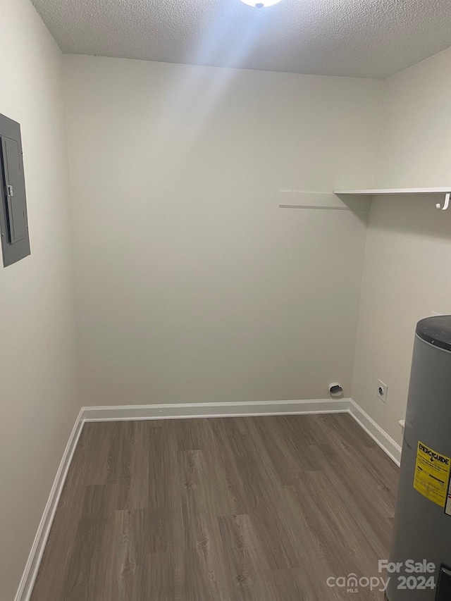 washroom featuring water heater, dark wood-type flooring, a textured ceiling, electric dryer hookup, and electric panel