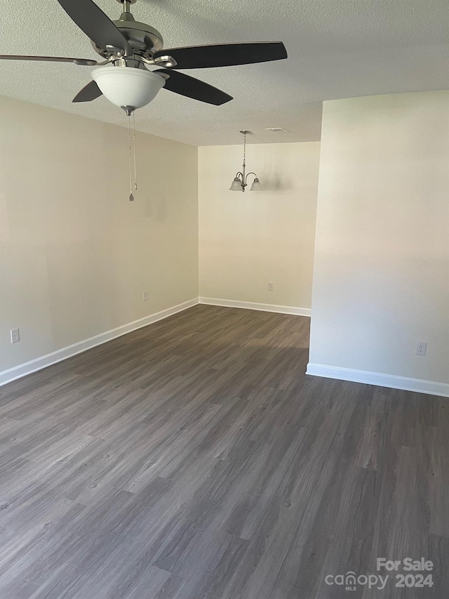 unfurnished room with a textured ceiling, ceiling fan, and dark hardwood / wood-style flooring