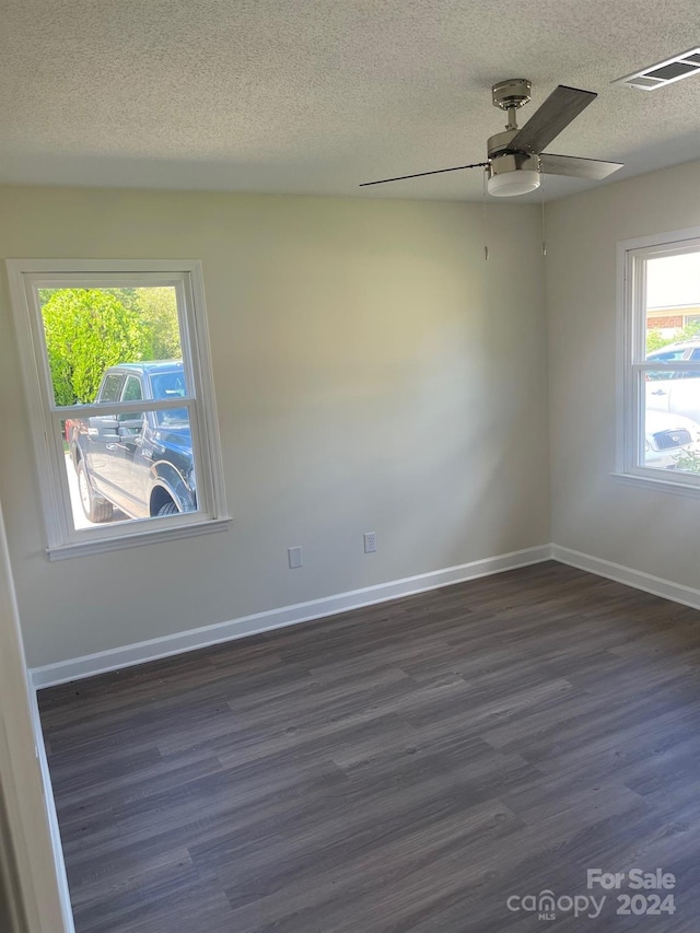 empty room with ceiling fan, a textured ceiling, and dark hardwood / wood-style flooring